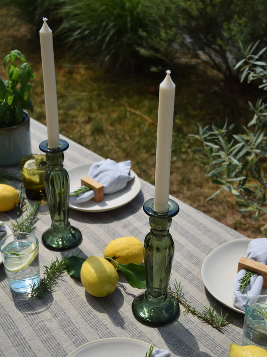Grüne Kerzenhalter mit Stabkerze auf einem sommerlich gedeckten Tisch