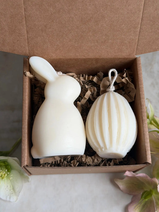 Osterhasen Kerze mit zwei Ohren und Ostereier Kerze mit Streifen in einer Geschenkbox aus Karton.