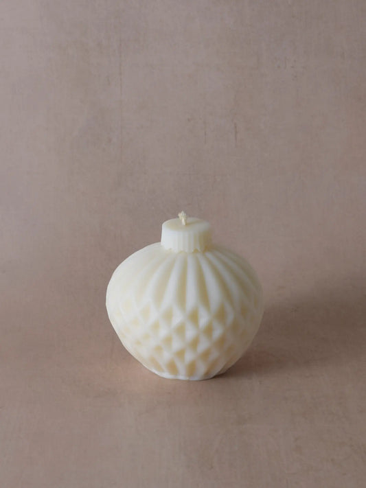 Naturfarbene Kerze in Weihnachtskugelform mit Streifen.