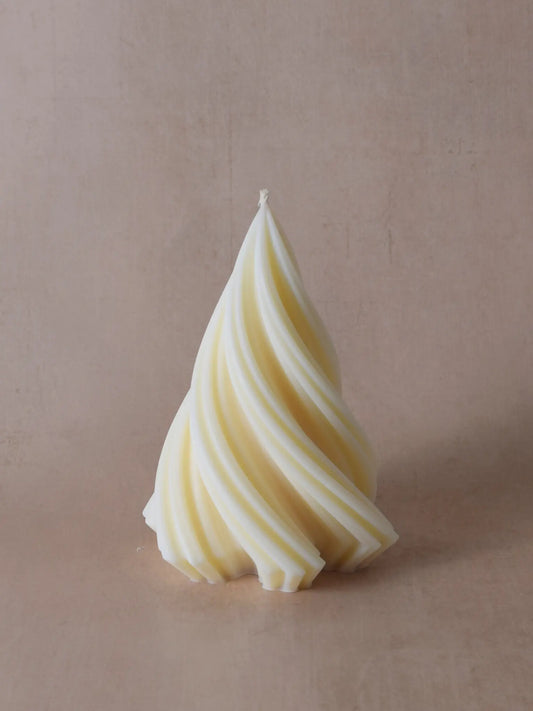 Grosse, naturfarbene Kerze in Weihnachtsbaumform vor einem beigen Hintergrund.