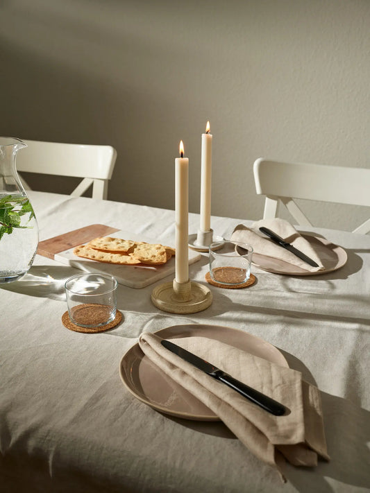 Zwei Stabkerzen auf einem gedeckten Tisch