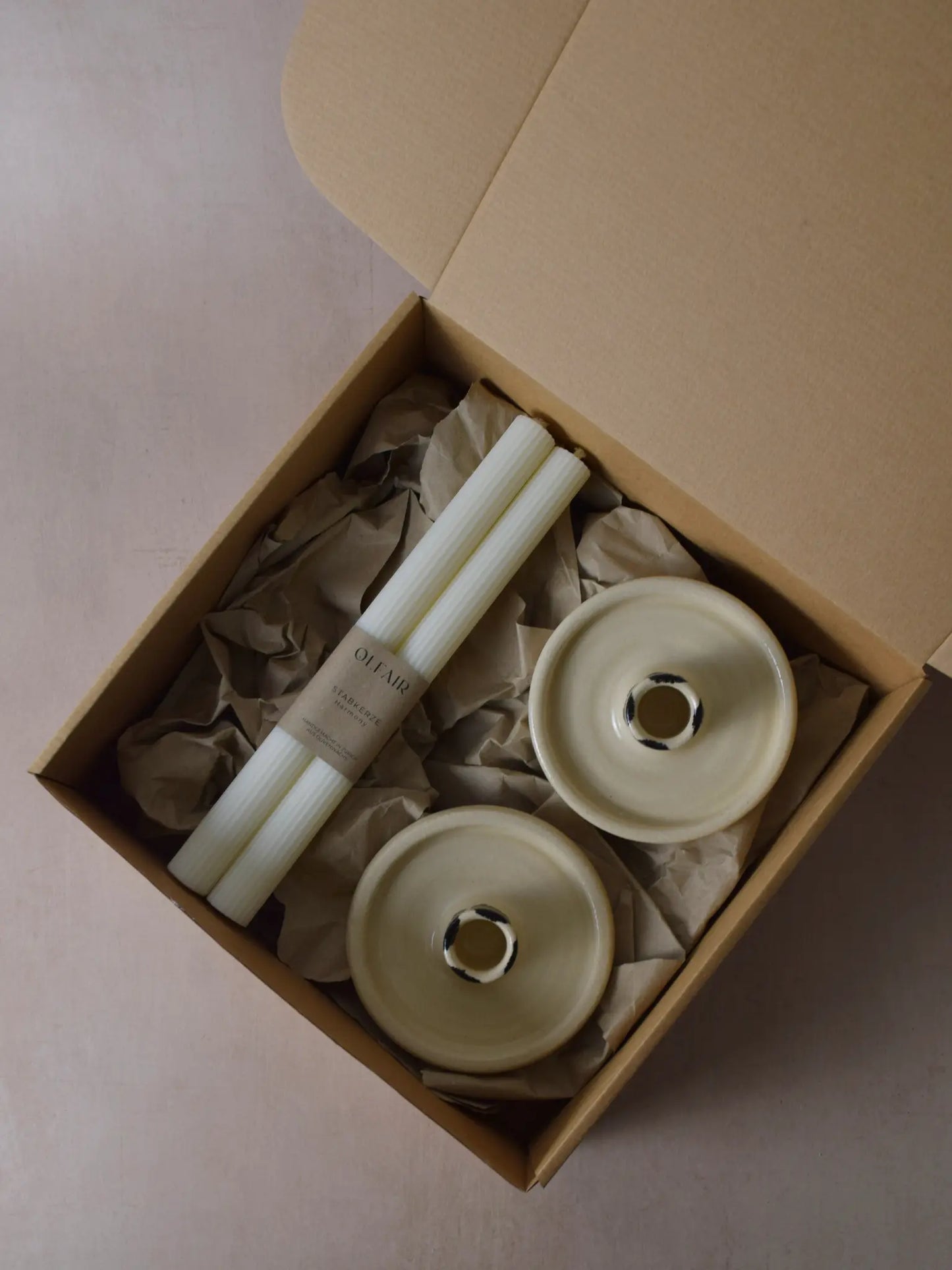 Geschenkset bestehend aus einem 2er-Set Stabkerzen mit kleinen Rillen und zwei Kerzenhaltern aus Keramik schwarz/weiss gestreift.