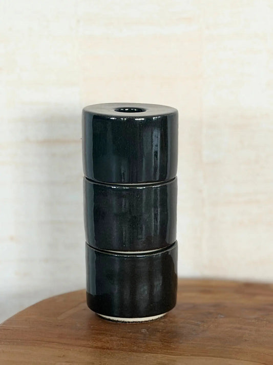 Kerzenhalter Modu in braun gestapelt auf einem Holztisch.