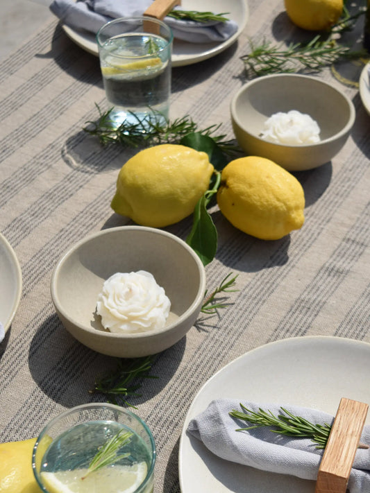 Dekokerzen in Pfingstrosenform auf einem sommerlich gedeckten Tisch