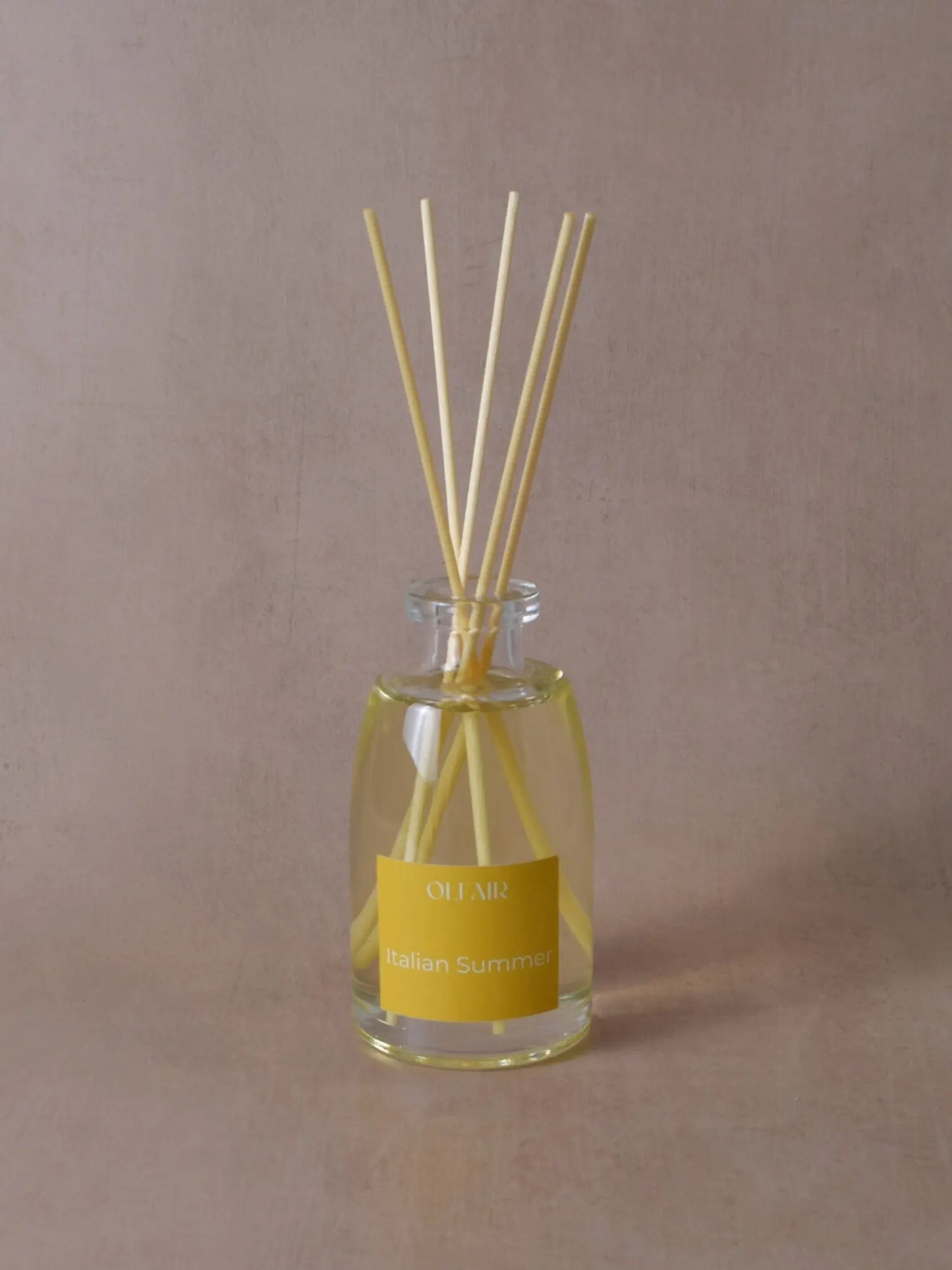 Grosser Raumduft mit Stäbchen und einem gelben Etikett vor einem beigen Hintergrund.