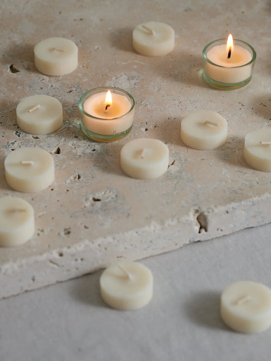 Stimmungsvolles Bild mit brennenden Teelichtern auf Natursteinplatte
