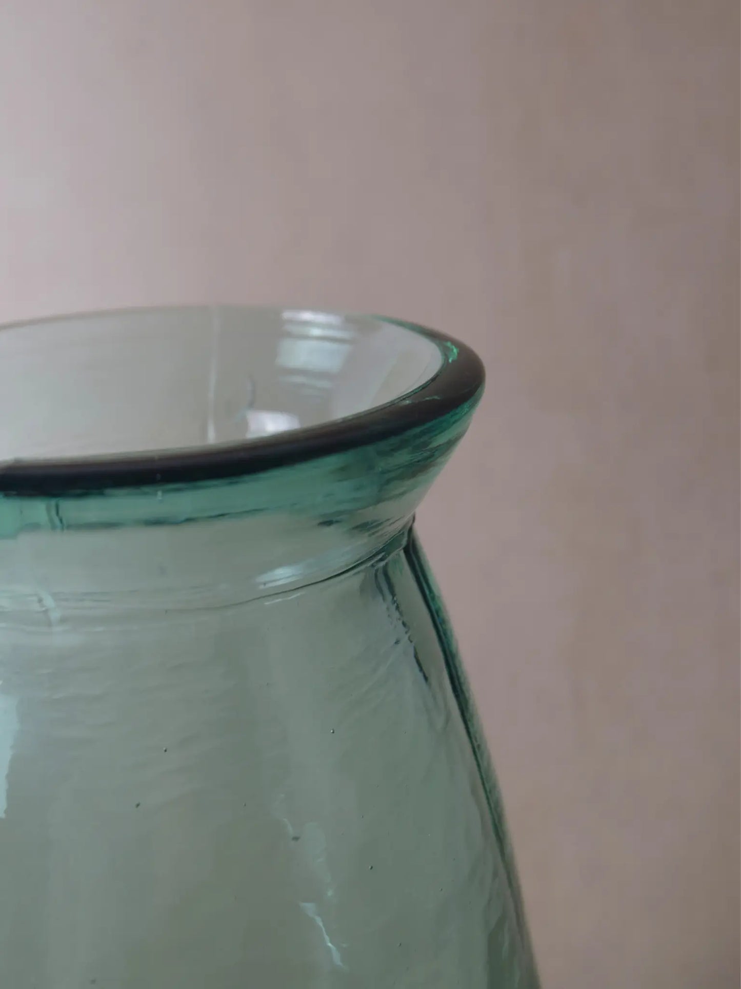 Nahaufnahme einer bläulichen, grossen Vase vor einem beigen Hintergrund