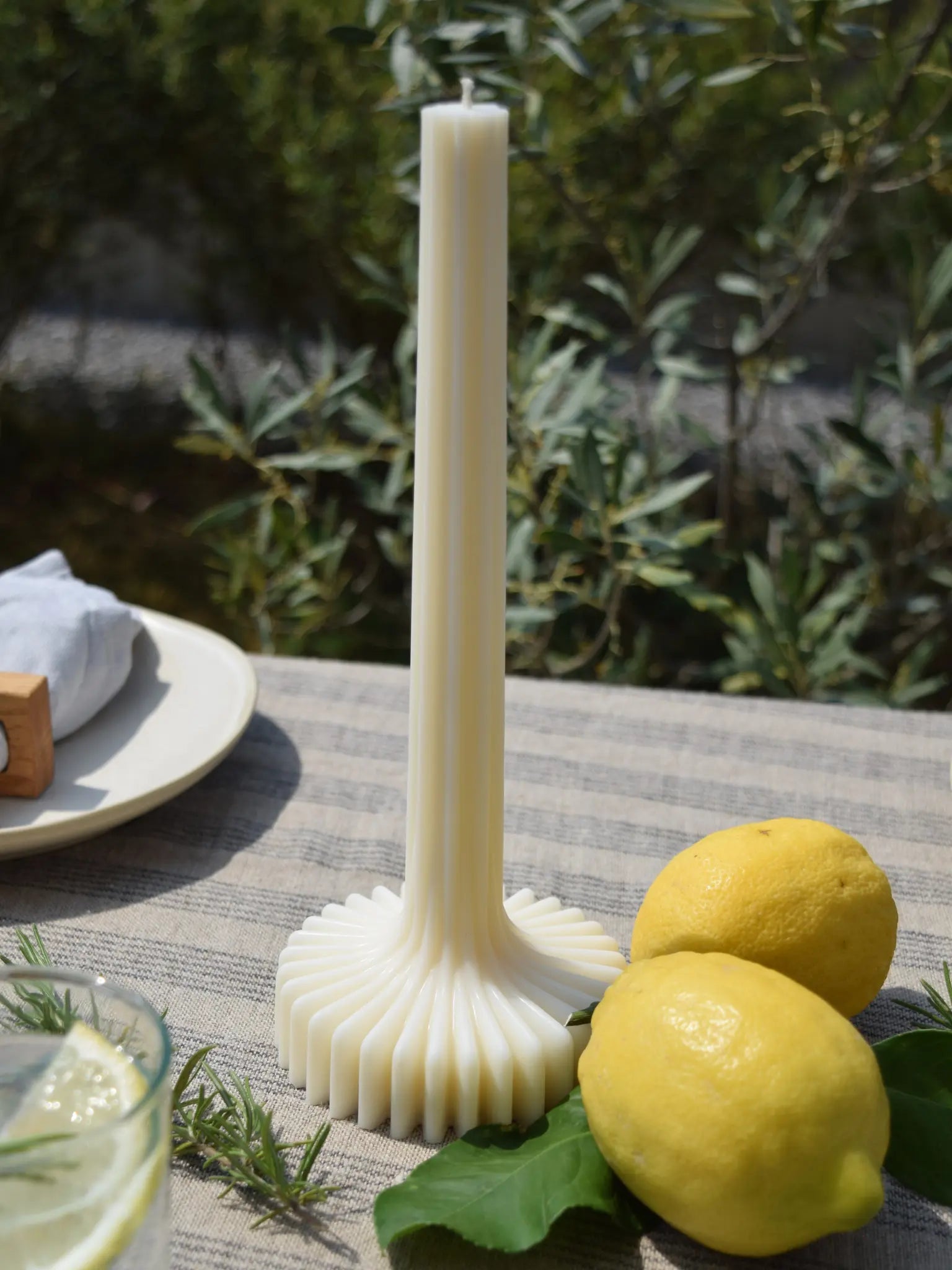 Stabkerze mit Basis auf einem sommerlich gedeckten Tisch
