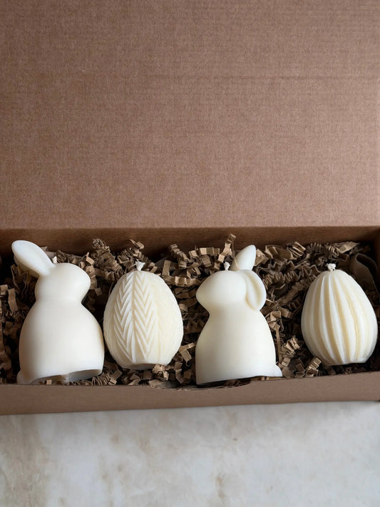 Zwei Osterhasen und zwei Ostereier Kerzen in einer Geschenkbox aus Karton.