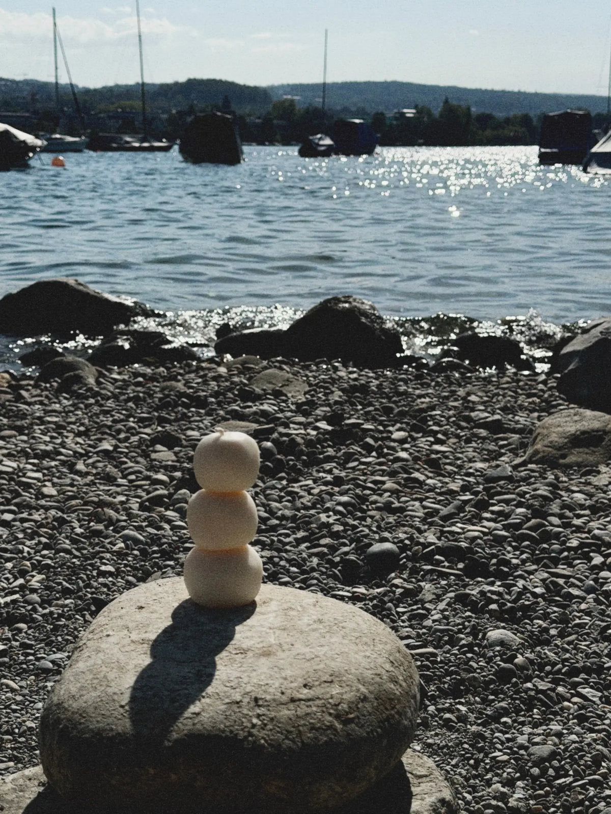 Dekokerze The Stack steht auf einem Steinhaufen am See.