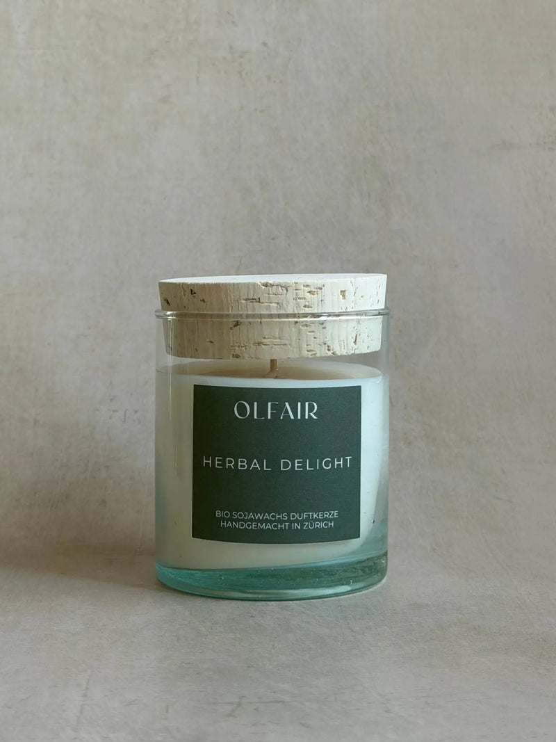 Duftkerze Herbal Delight in einem durchsichtigen Glas mit einem Korkdeckel.
