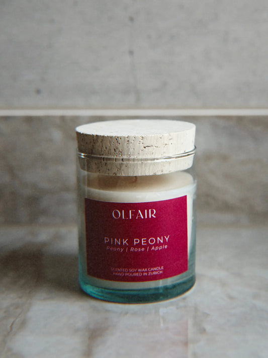 Duftkerze Pink Peony vor einem Marmor Hintergrund.