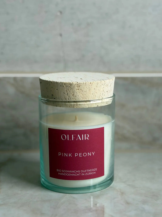 Duftkerze Pink Peony vor einem Marmor Hintergrund.