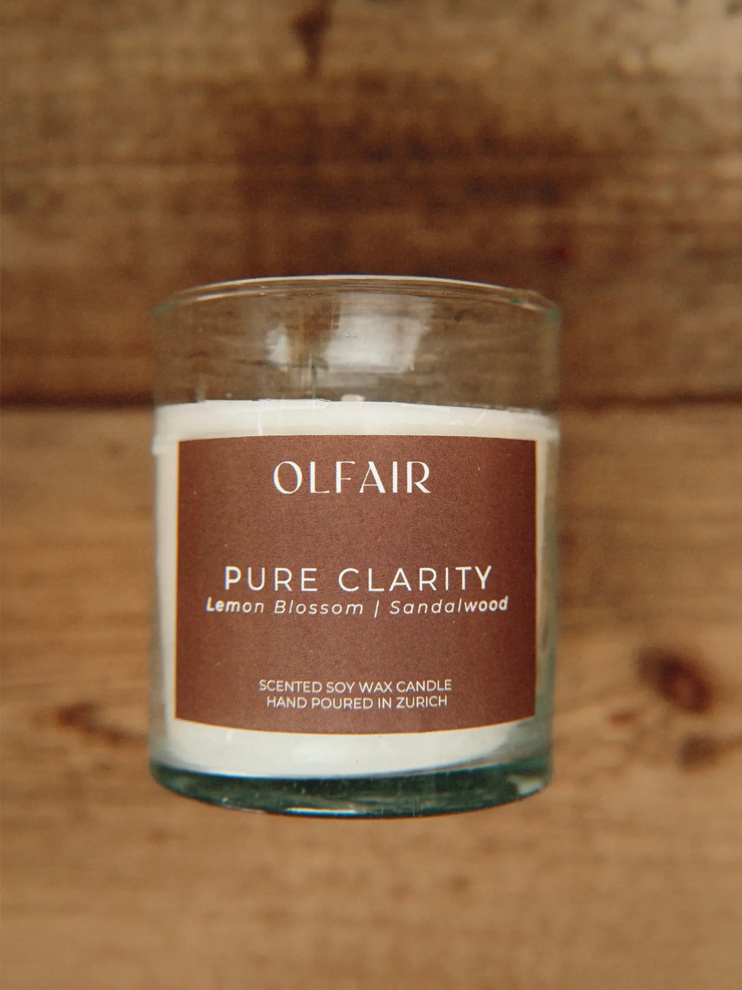 Duftkerze Pure Clarity auf einem Holzbrett