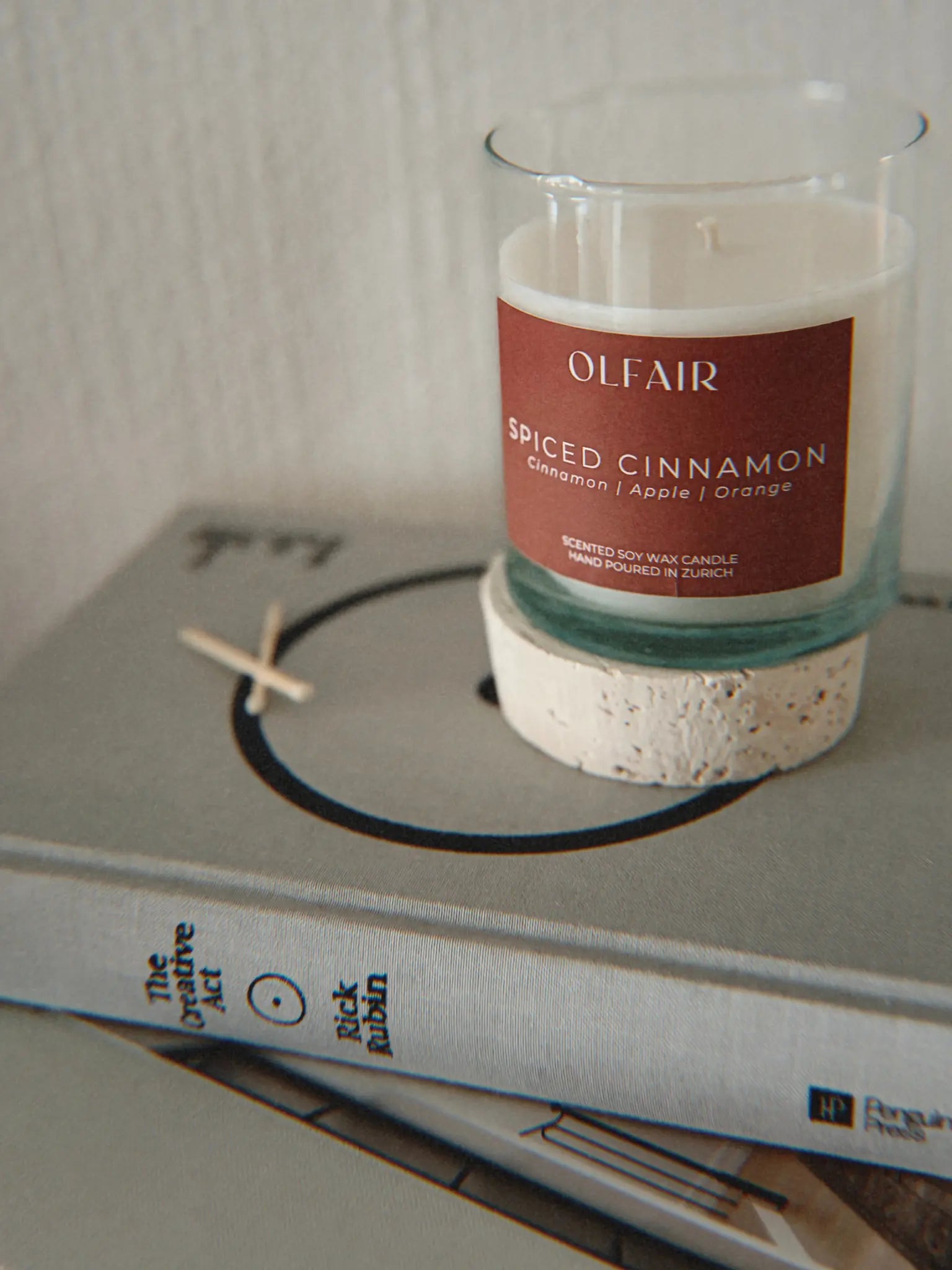 Duftkerze Spiced Cinnamon auf einem Stapel aus Büchern.