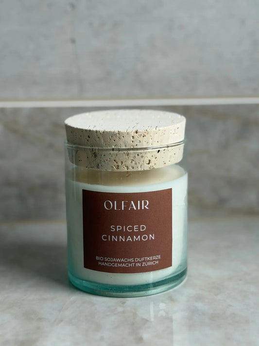 Duftkerze Spiced Cinnamon vor einem Marmor Hintergrund.