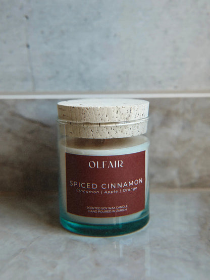 Duftkerze Spiced Cinnamon vor einem Marmor Hintergrund.