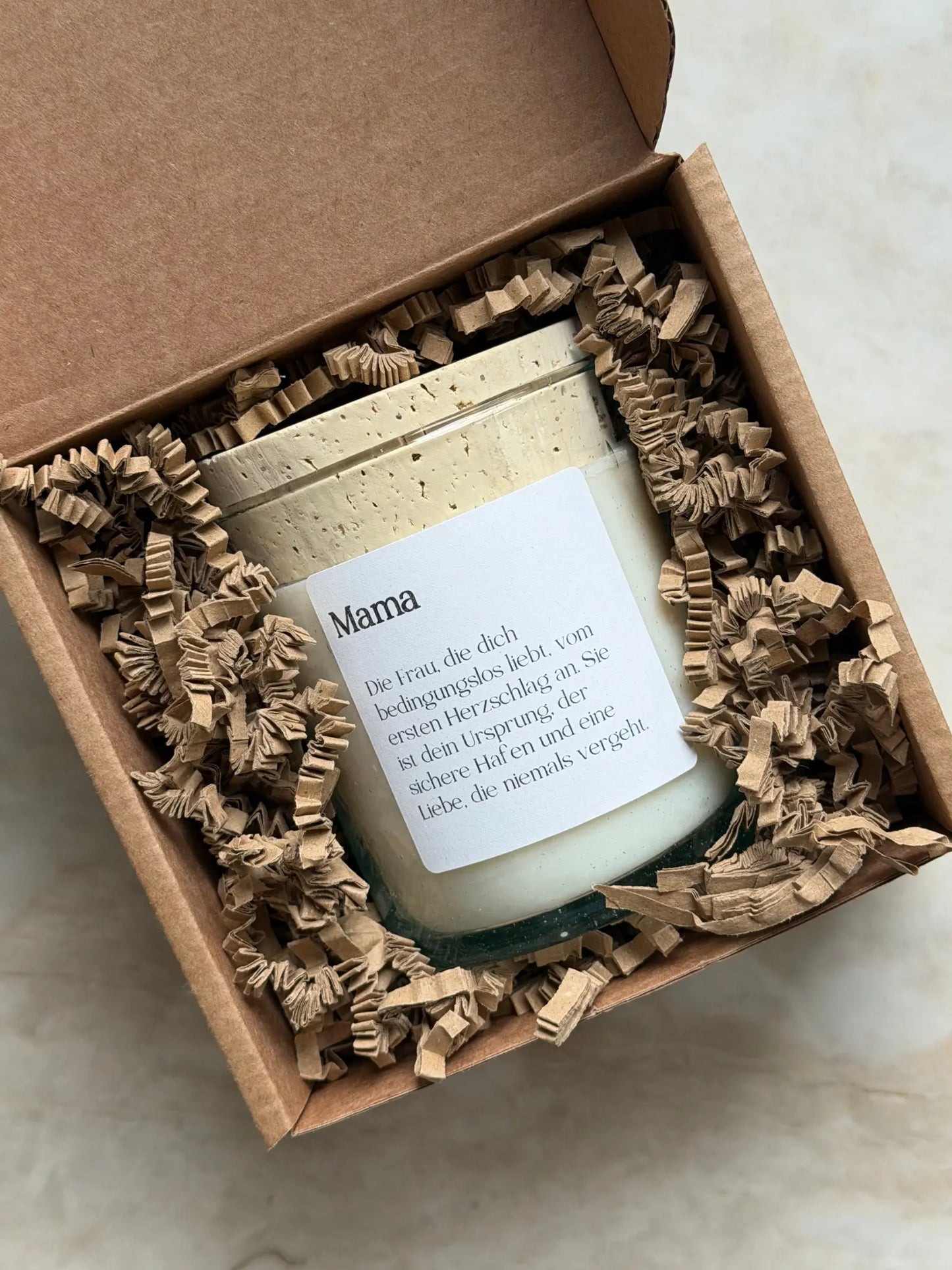 Duftkerze mit einem weissen, personalisierbaren Etikett und einem Kork Deckel in einer Geschenkschachtel.