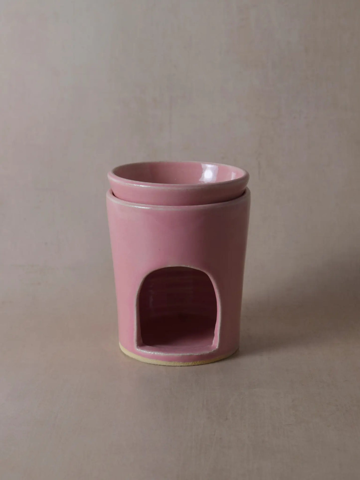 Duftlampe in rosa auf einem beigen Hintergrund.