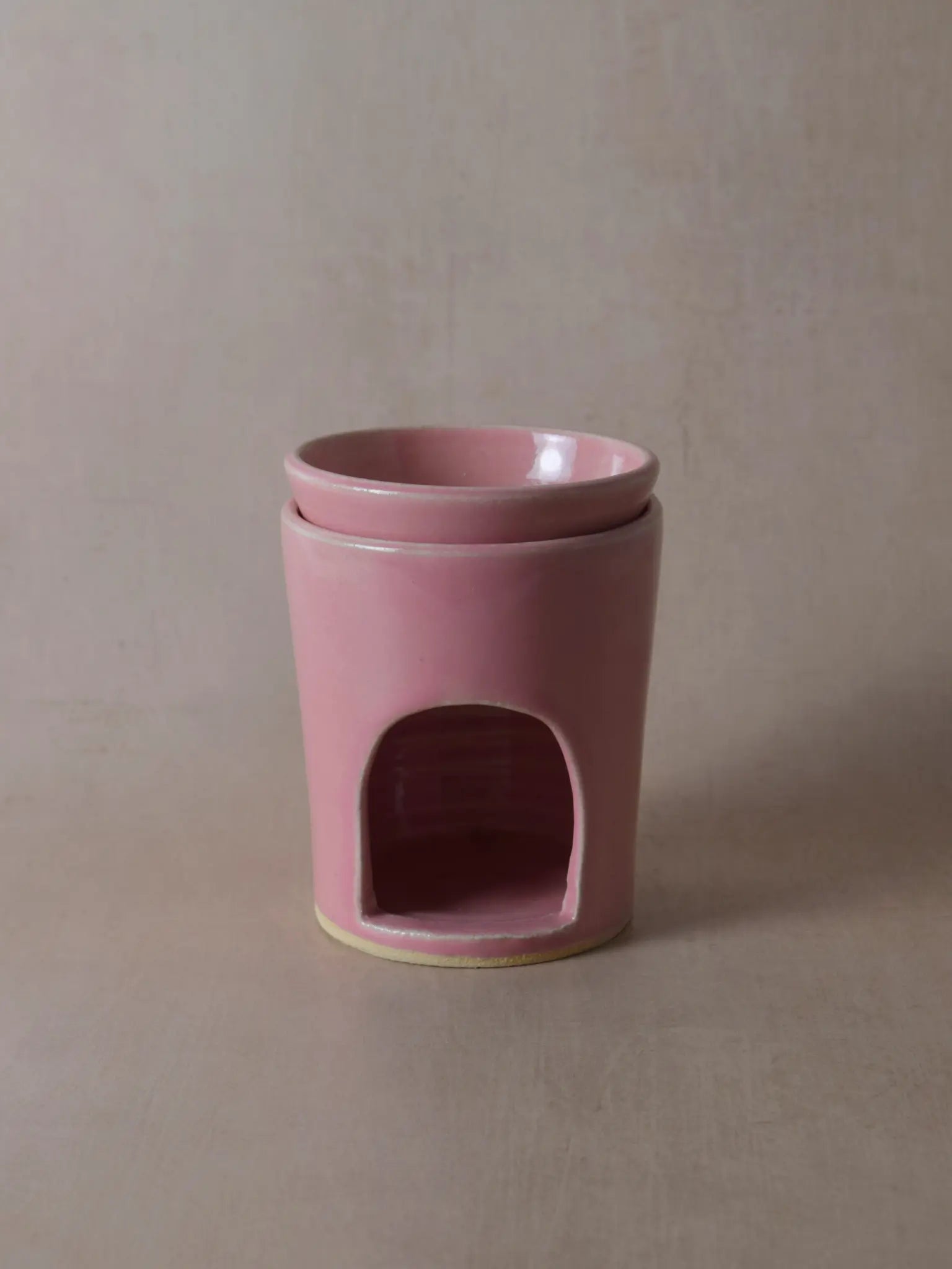 Duftlampe in rosa auf einem beigen Hintergrund.