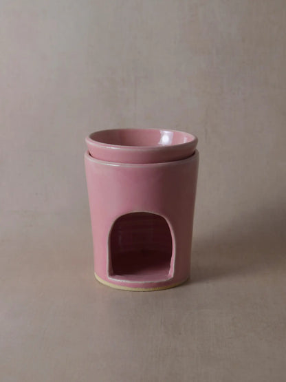 Duftlampe in rosa auf einem beigen Hintergrund.