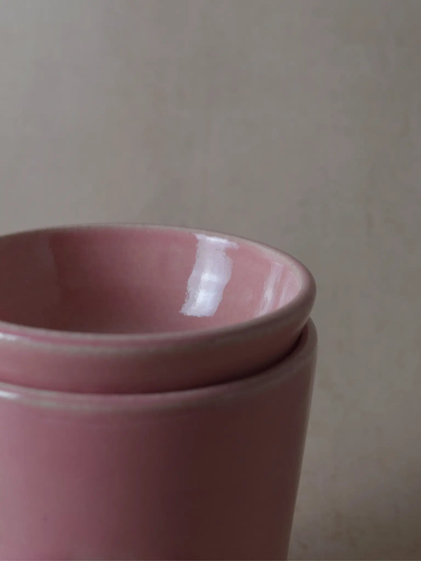 Teilaufnahme einer Duftlampe in rosa auf einem beigen Hintergrund.