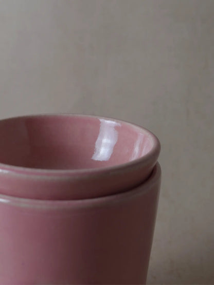 Teilaufnahme einer Duftlampe in rosa auf einem beigen Hintergrund.