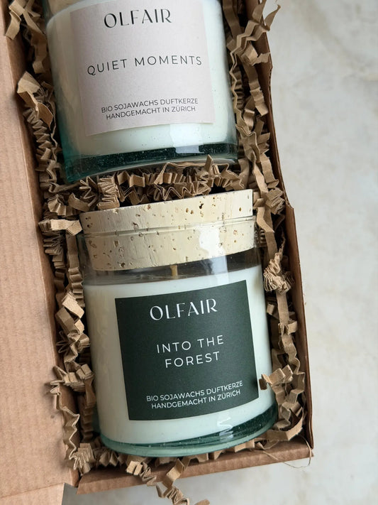 Nahaufnahme Duftkerzen Duo in einer Geschenkbox vor einem Marmor Hintergrund.