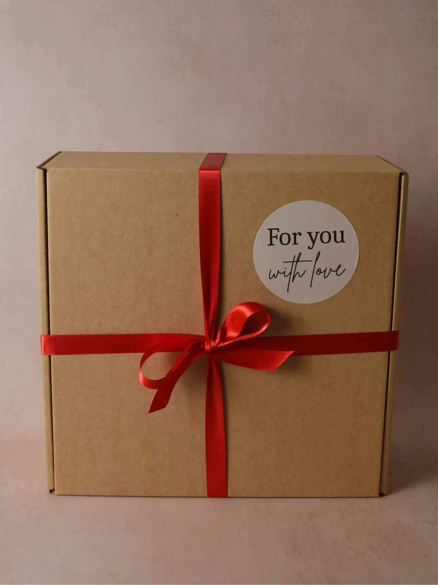 Geschenkset Verpackung aus Kartonschachtel und roter Schleife.