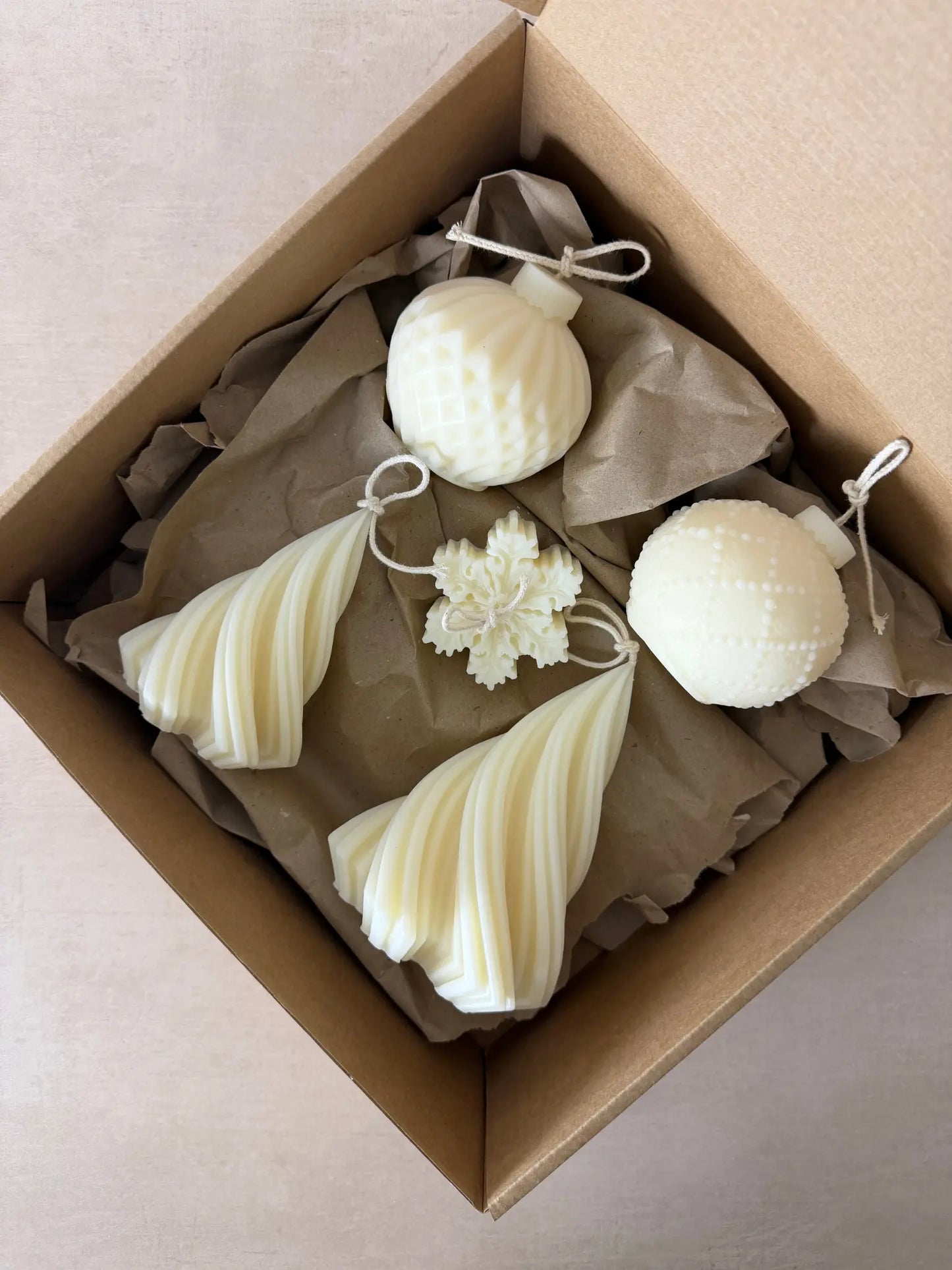 Geschenkset bestehend aus einer kleinen Tannenbaumkerze, einer grossen Tannenbaumkerze, zwei Weihnachtsbaumkugelkerzen in unterschiedlichem Design und einer Kerze in Schneeflockenform.