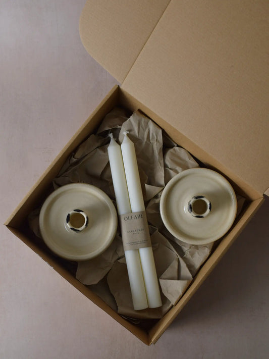 Geschenkset bestehend aus einem 2er-Set glatten Stabkerzen und zwei Kerzenhaltern aus Keramik schwarz/weiss gestreift.
