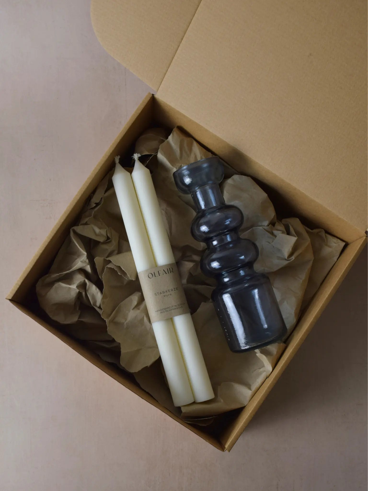 Geschenkset bestehend aus einem 2er-Set glatten Stabkerzen und einem Kerzenhalter in blau aus Recycling-Glas