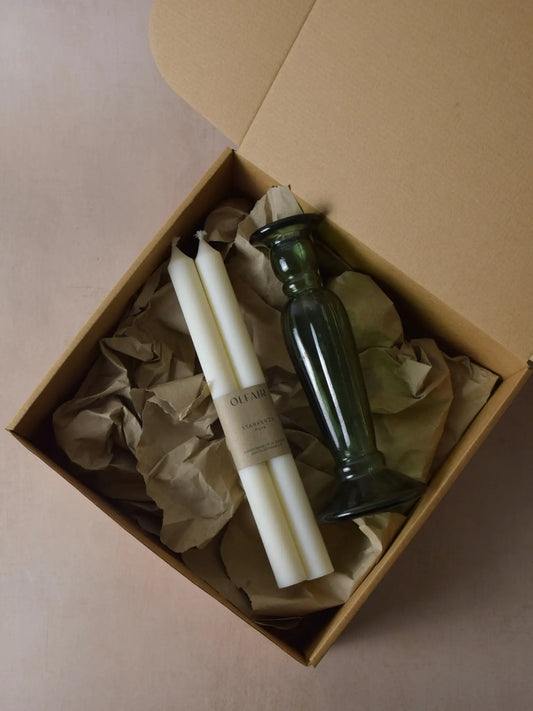 Geschenkset bestehend aus einem 2er-Set glatten Stabkerzen und einem grünen Kerzenhalter aus Recycling-Glas