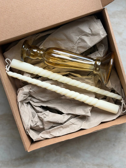 Geschenkset bestehend aus einem 2er-Set gedrehter Stabkerzen und einem bernsteinfarbenen Kerzenhalter aus Recycling-Glas