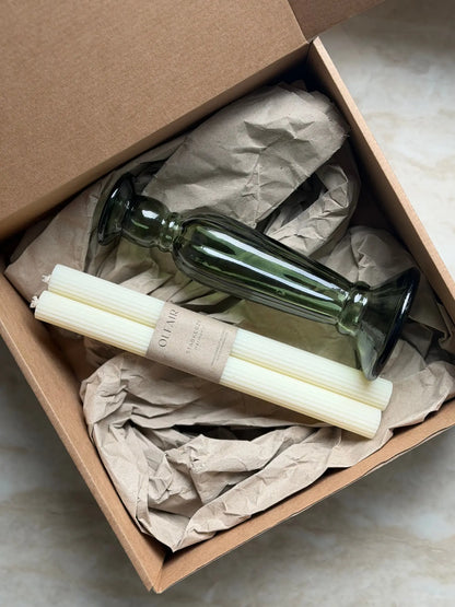 Geschenkset bestehend aus einem 2er-Set Stabkerzen mit kleinen Rillen und einem grünen Kerzenhalter aus Recycling-Glas