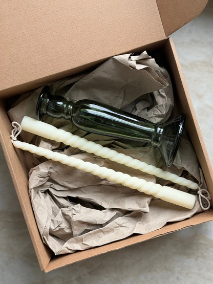 Geschenkset bestehend aus einem 2er-Set gedrehter Stabkerzen und einem grünen Kerzenhalter aus Recycling-Glas
