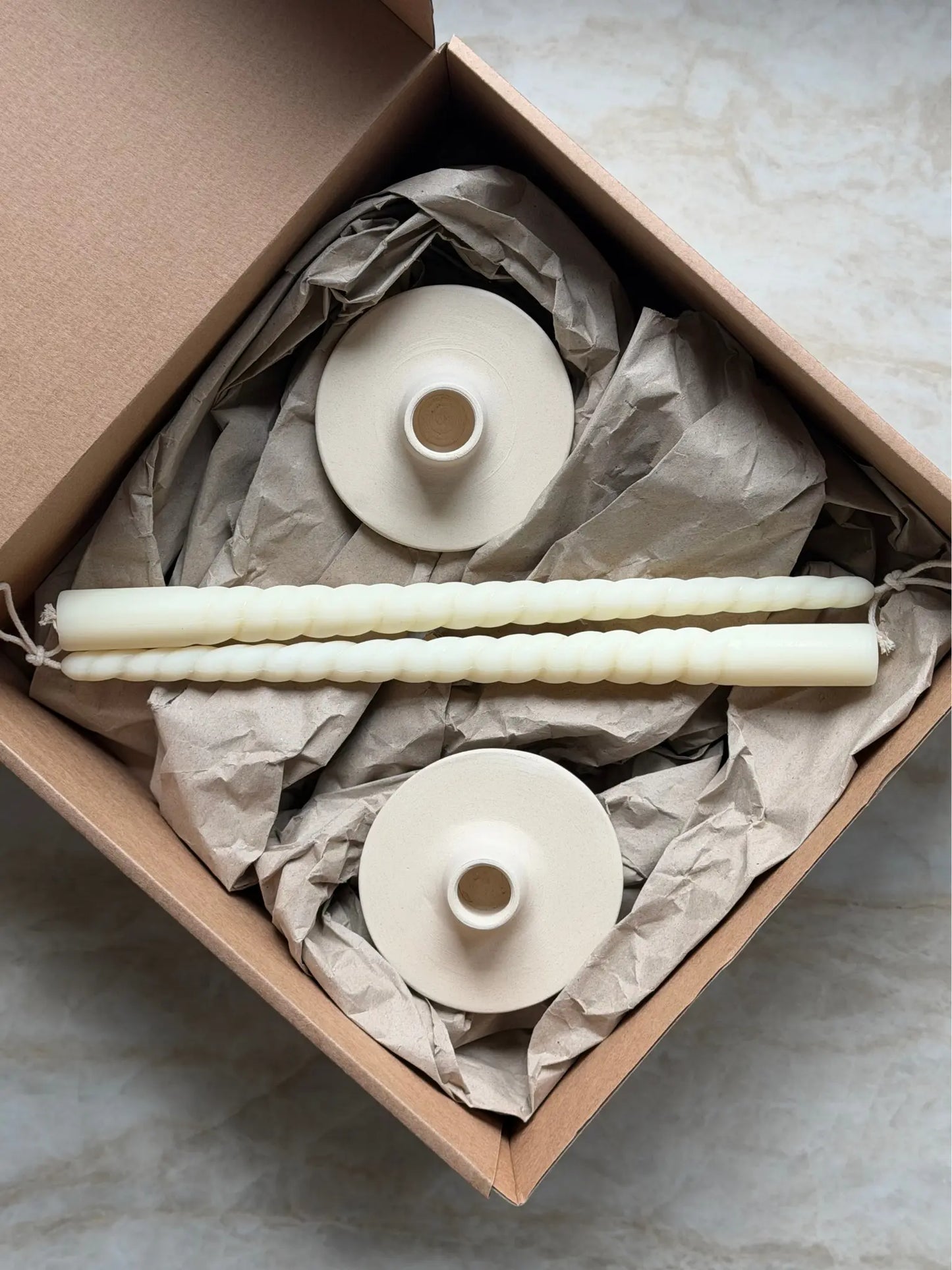 Geschenkset bestehend aus einem 2er-Set gedrehter Stabkerzen und zwei Kerzenhalter aus Keramik.