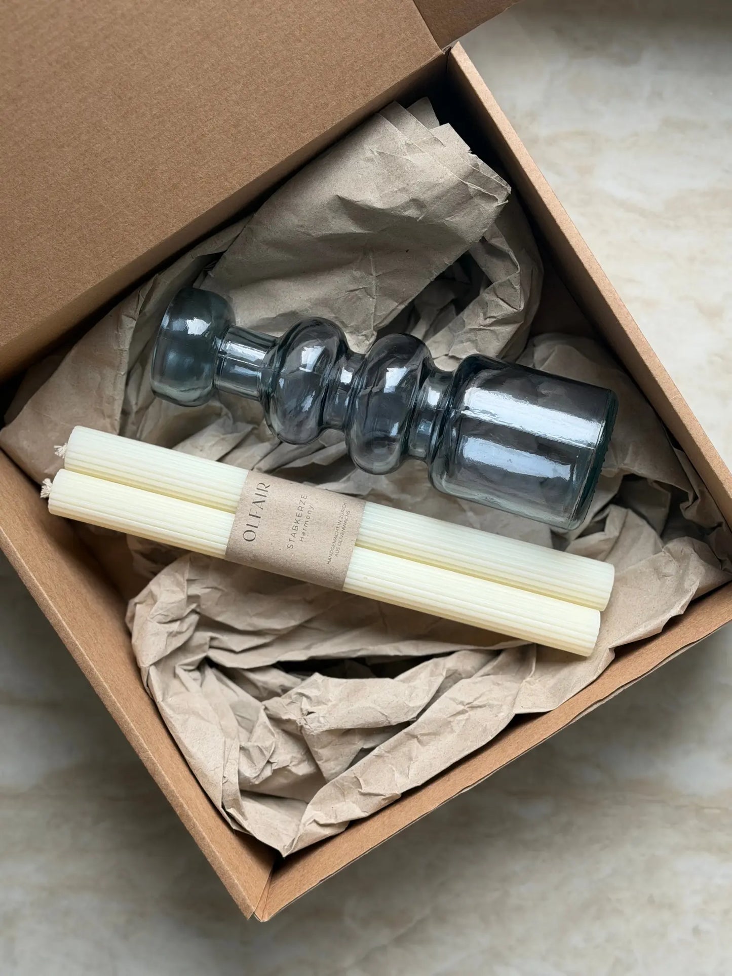 Geschenkset bestehend aus einem 2er-Set Stabkerzen mit leichten Rillen und einem Kerzenhalter in blau aus Recycling-Glas