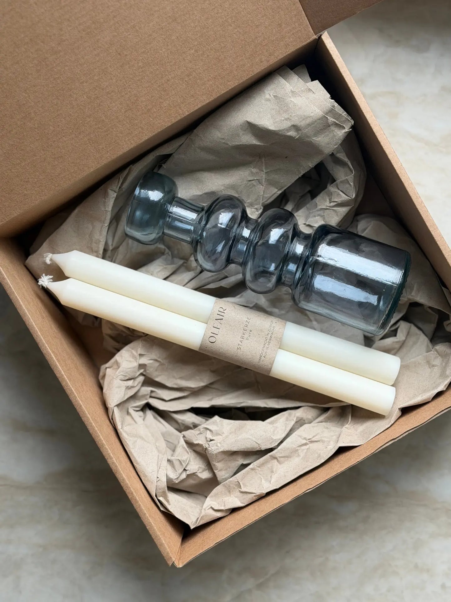 Geschenkset bestehend aus einem 2er-Set glatten Stabkerzen und einem Kerzenhalter in blau aus Recycling-Glas