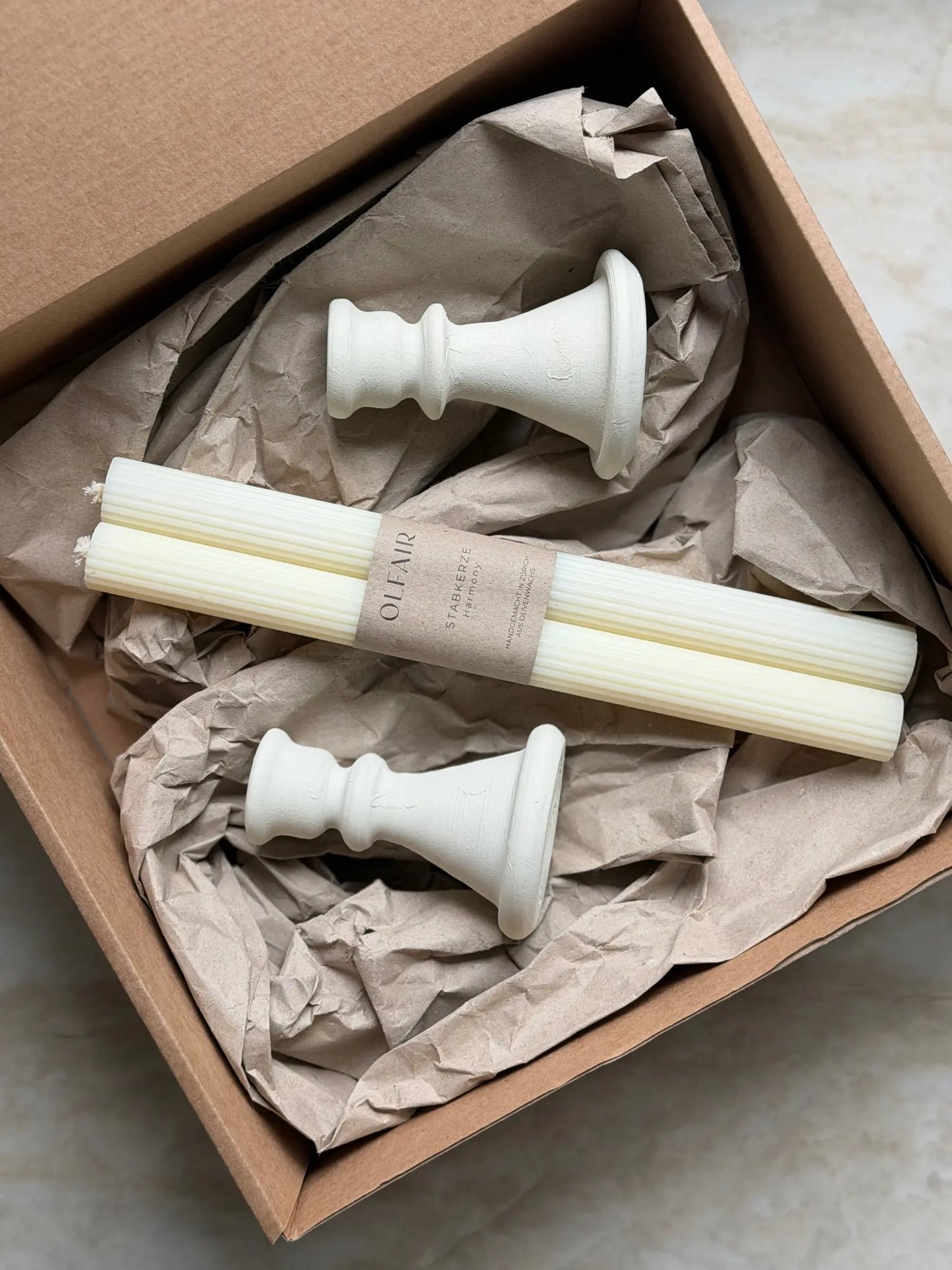 Geschenkset bestehend aus einem 2er-Set gerillter Stabkerzen und zwei Kerzenhalter aus Keramik.