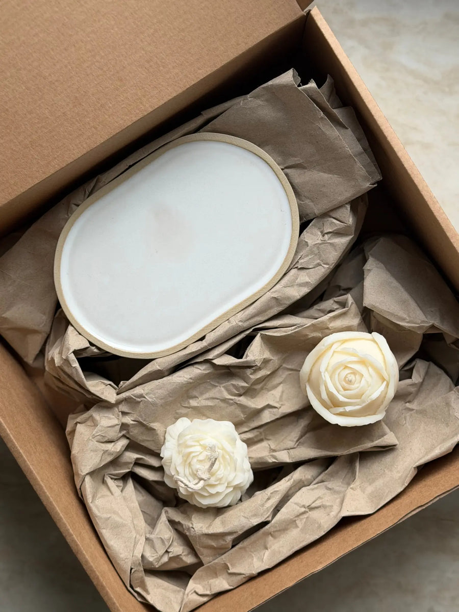 Geschenkset mit einer Rosen- und Pfingstrosenkerze und einem Kerzenteller aus Keramik in einer Kartonbox.