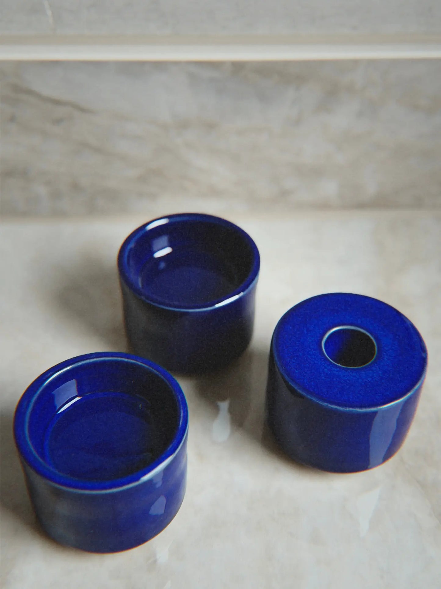 Nahaufnahme Kerzenhalter Modu in blau auseinandergenommen auf einem Marmor Hintergrund.