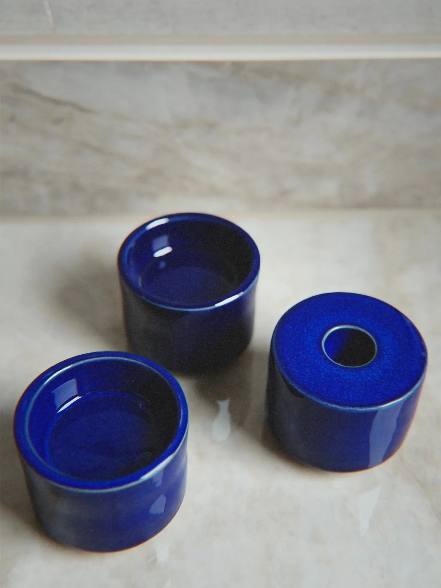 Nahaufnahme Kerzenhalter Modu in blau auseinandergenommen auf einem Marmor Hintergrund.