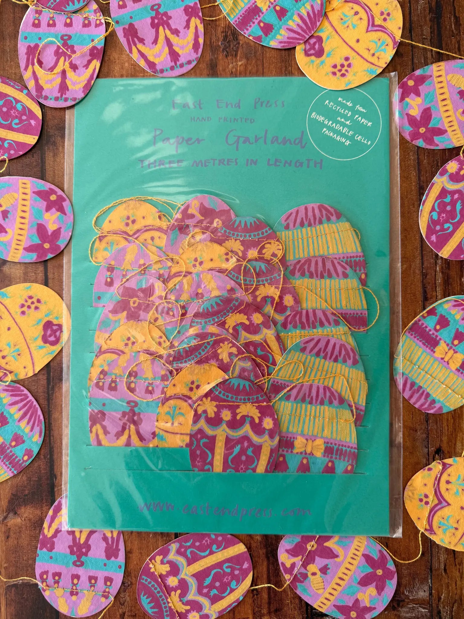 Verpackte Girlande mit Ostereier. Eine Ostereier Girlande liegt umd die Verpackung.