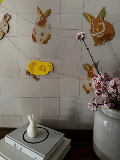 Ostergirlande mit Häschen, Küken und Osterglocken aufgehängt.