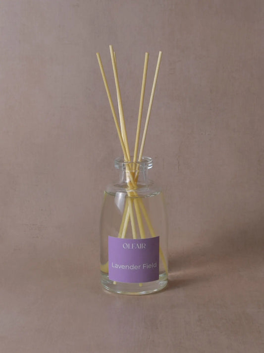 Grosser Raumduft mit Stäbchen und einem violetten Etikett vor einem beigen Hintergrund.