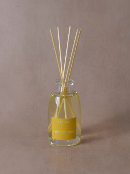 Grosser Raumduft mit Stäbchen und einem gelben Etikett vor einem beigen Hintergrund.