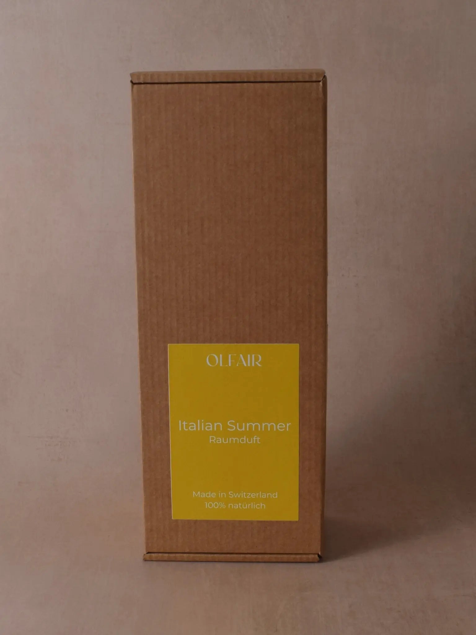 Kartonbox mit einem gelben Etikett vor einem beigen Hintergrund.