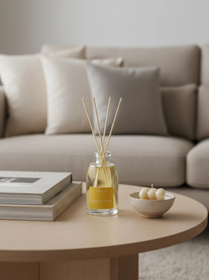 Raumdfut Italian Summer stehend auf einem hellen Holzcouchtisch. Es stehen eine Bubble-Kerze und mehrere Bücher auf dem Tisch. Im Hintergrund ist ein helles Sofa zu sehen.