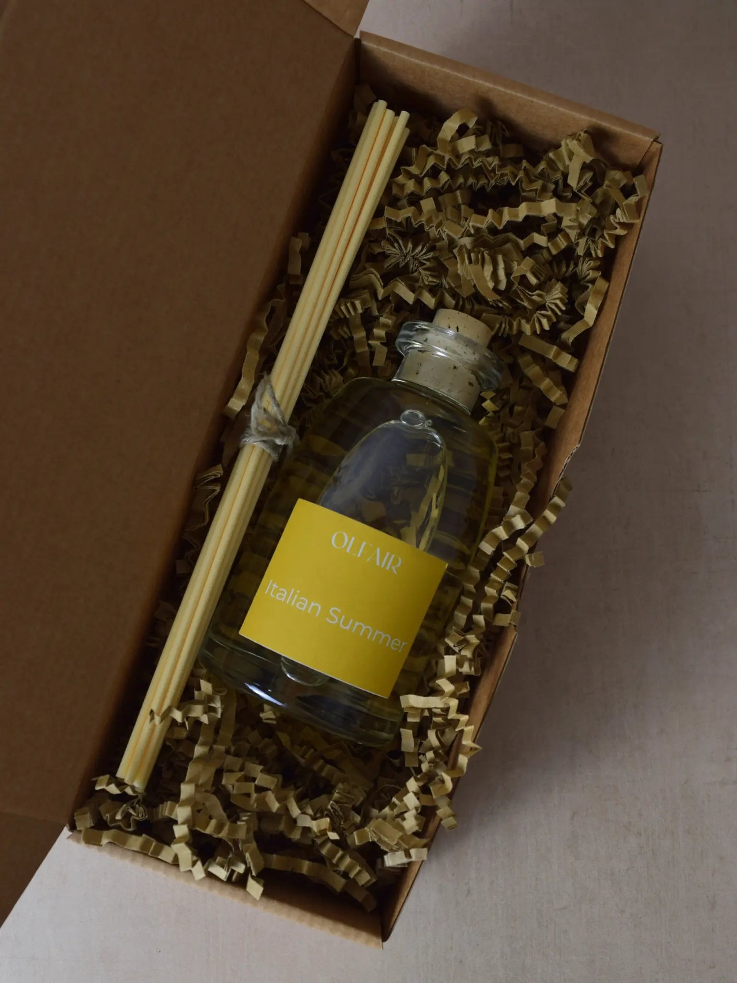 Raumduft mit gelber Etikette mit Stäbchen in einer Box.